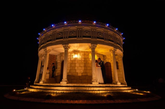 Temple lumineux la nuit, avec une mariée et un décor romantique.