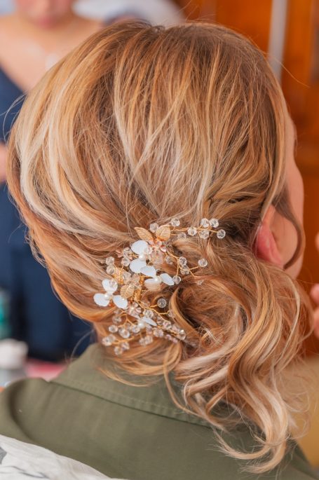 Coiffure élégante avec des fleurs blanches dans des cheveux ondulés.